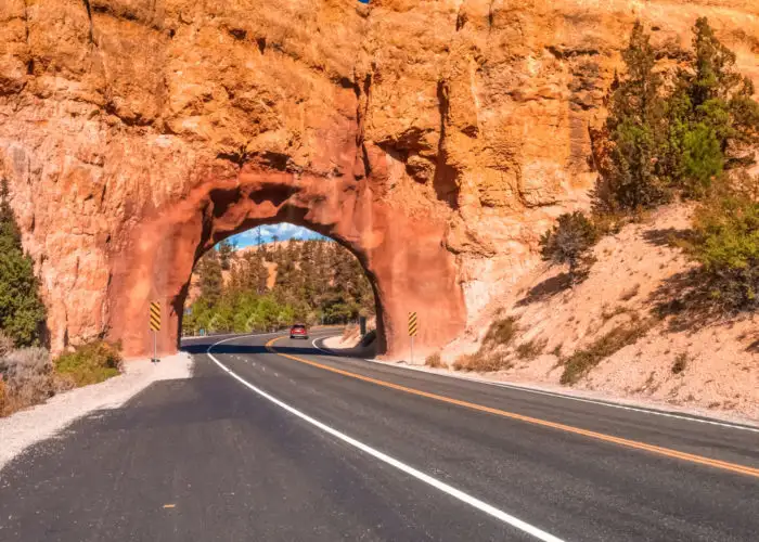 Road running under stone arch at the entrance of Bryce Canyon National Park