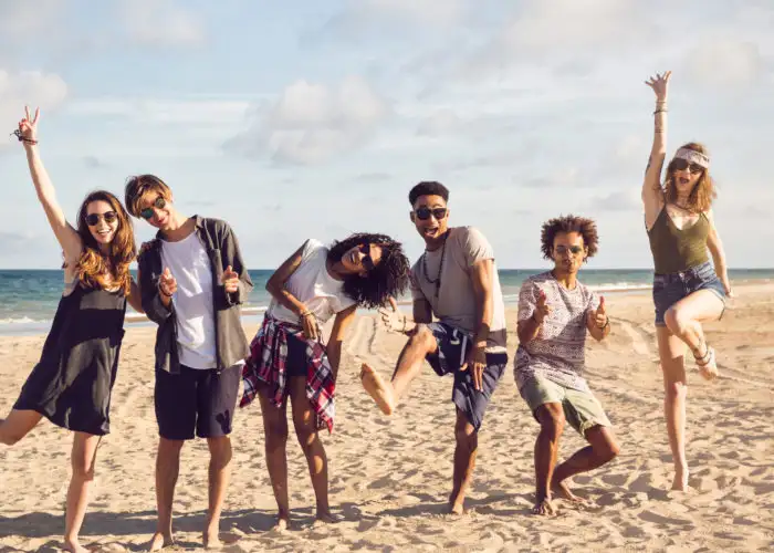 Group of friends jumping and having a good time on the beach
