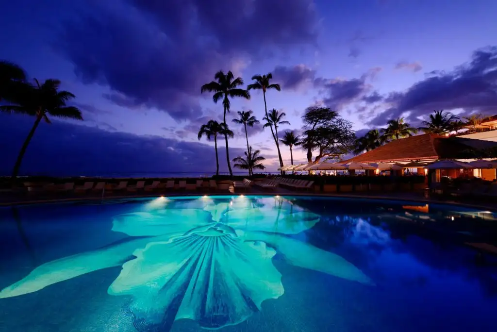 Pool facing the ocean at night at hotel Halekulani 