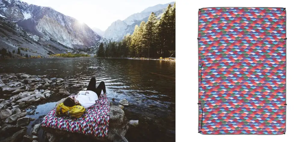 Person laying on the Coalatree Kachula Blanket on rocks by a lake in between mountains (left) and the Coalatree Kachula Blanket laid flat (right)