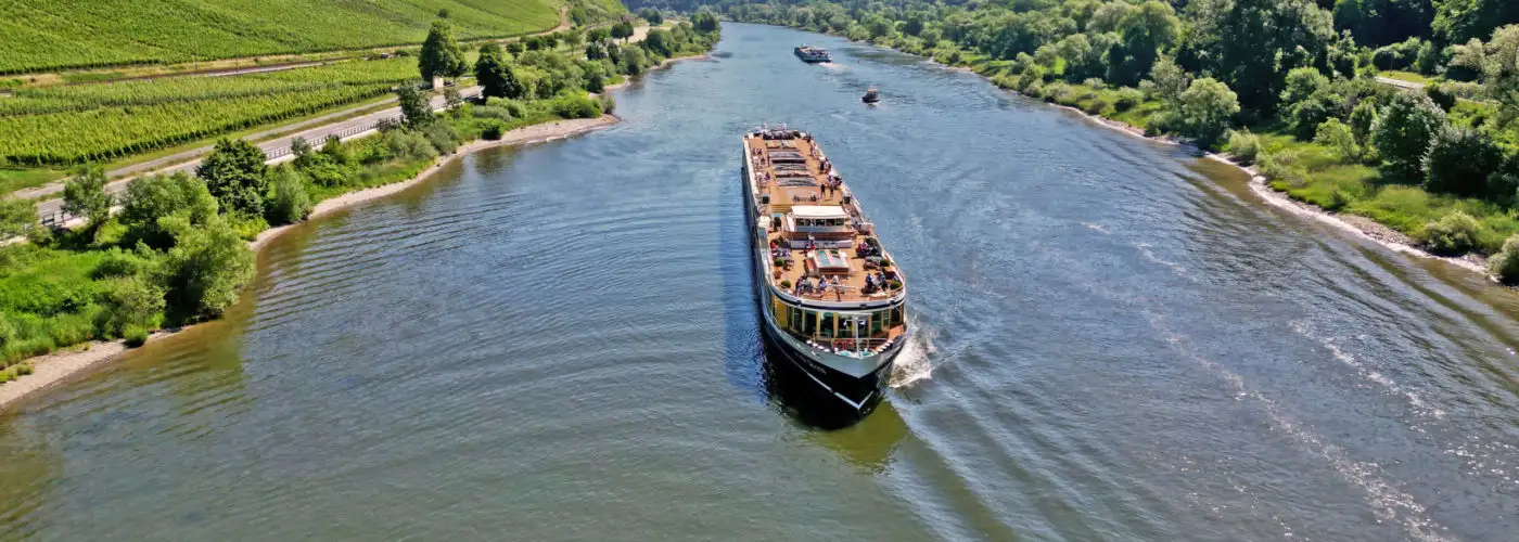 Aerial view of a Uniworld River Cruises ship passing through a river valley