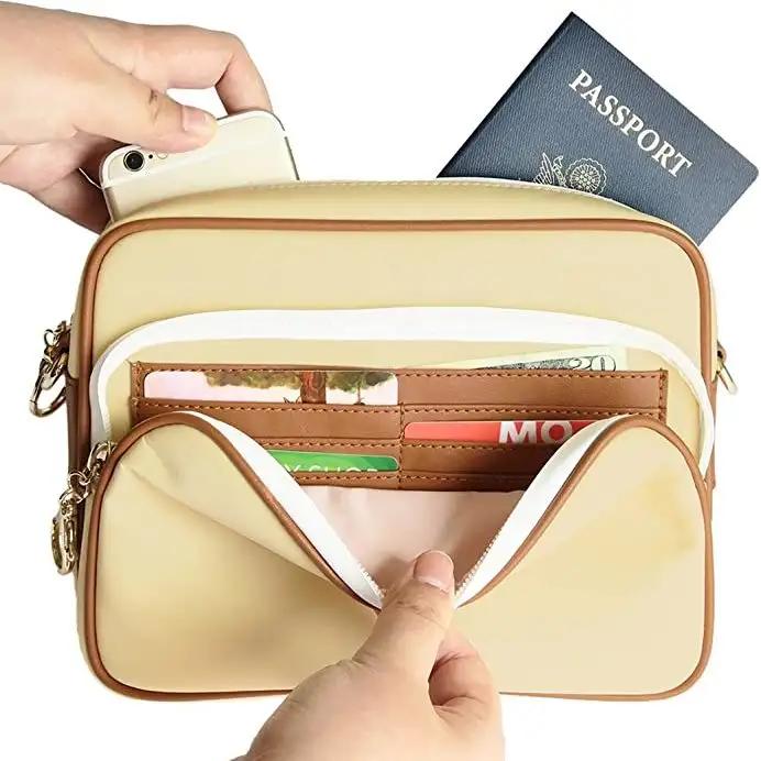 Arden Cove Waterproof Anti-Theft Cross-Body Bags in cream filled with travel documents, cash, and a passport