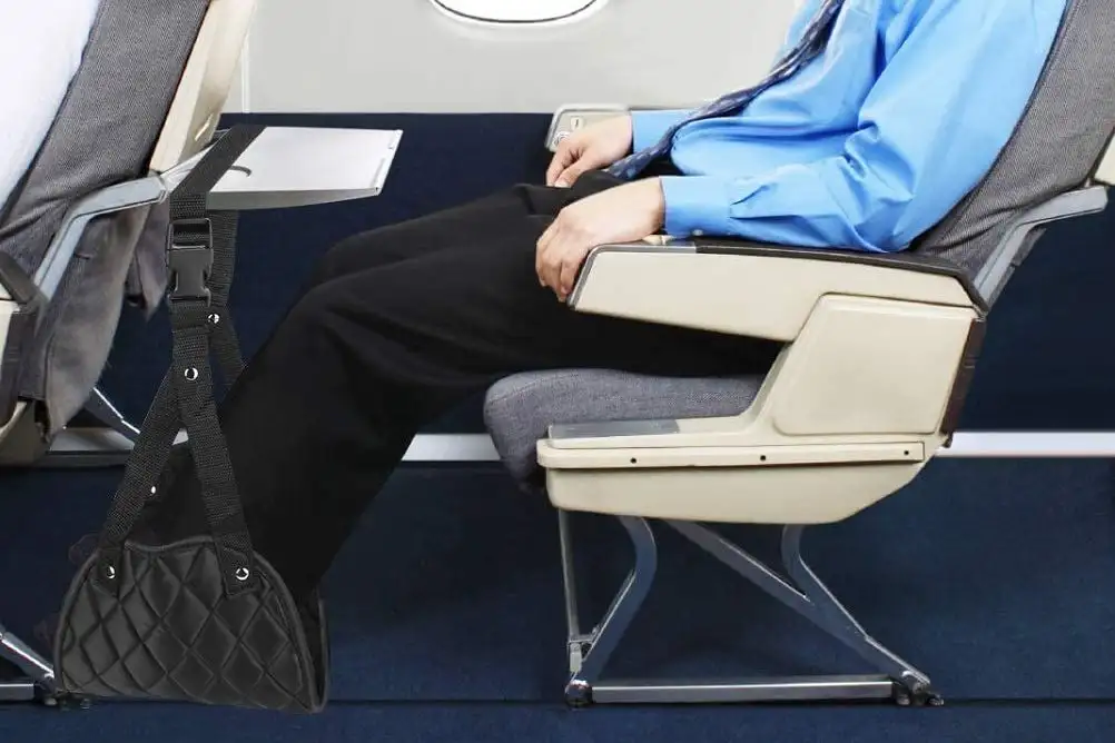 Close up of person using the Angemay foot hammock footrest on airplane