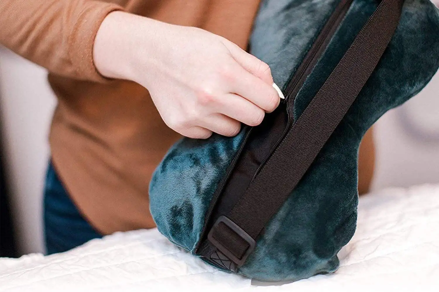 Close up of person zipping up the AirComfy lumbar pillow in its removable case