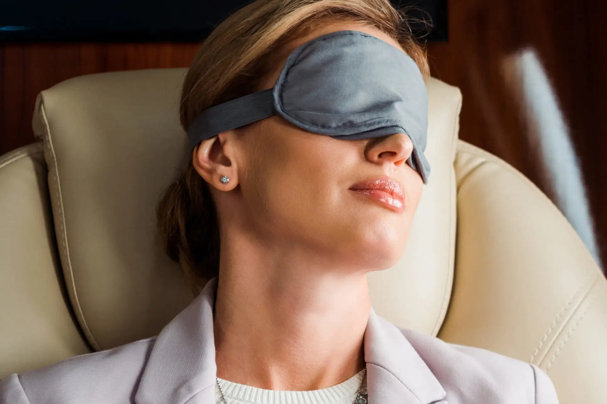 Woman sleeping on plane wearing a sleep mask