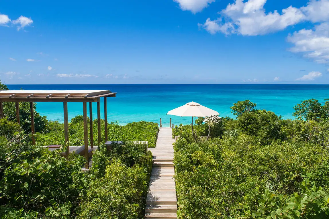 Wooden pathway leading to the ocean from a bungalow at Amanyara