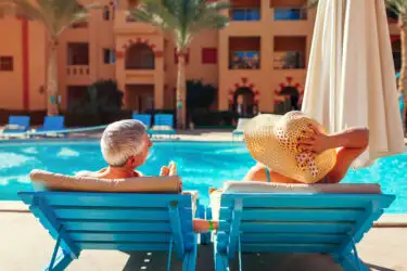 Senior couple relaxing by the pool at an all-inclusive resort