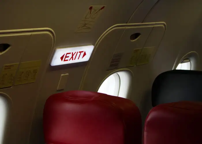 Close up of exit sign in exit row of plane