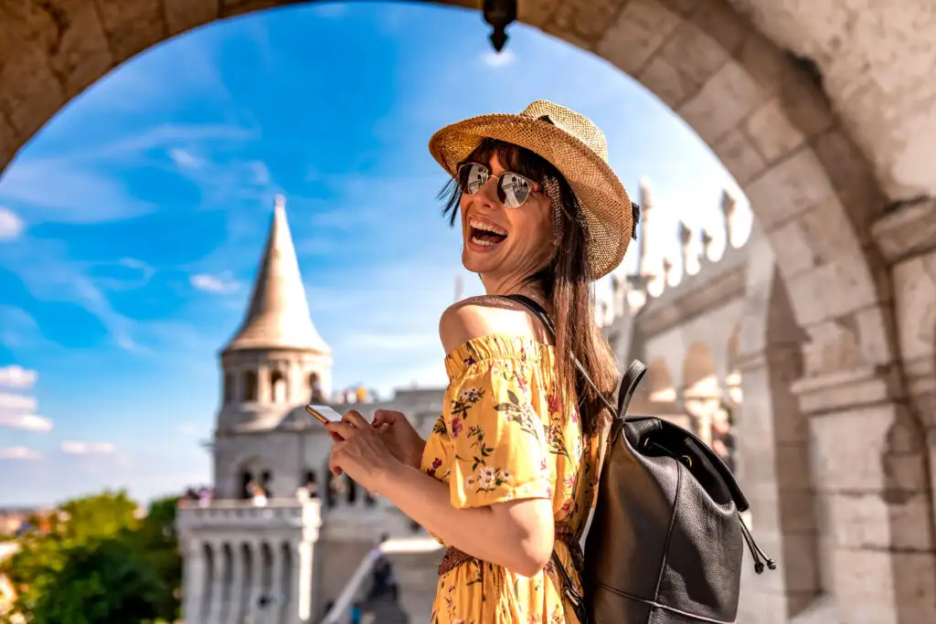 Laughing woman under an archway in front of the Castle of Budapest in Hungary