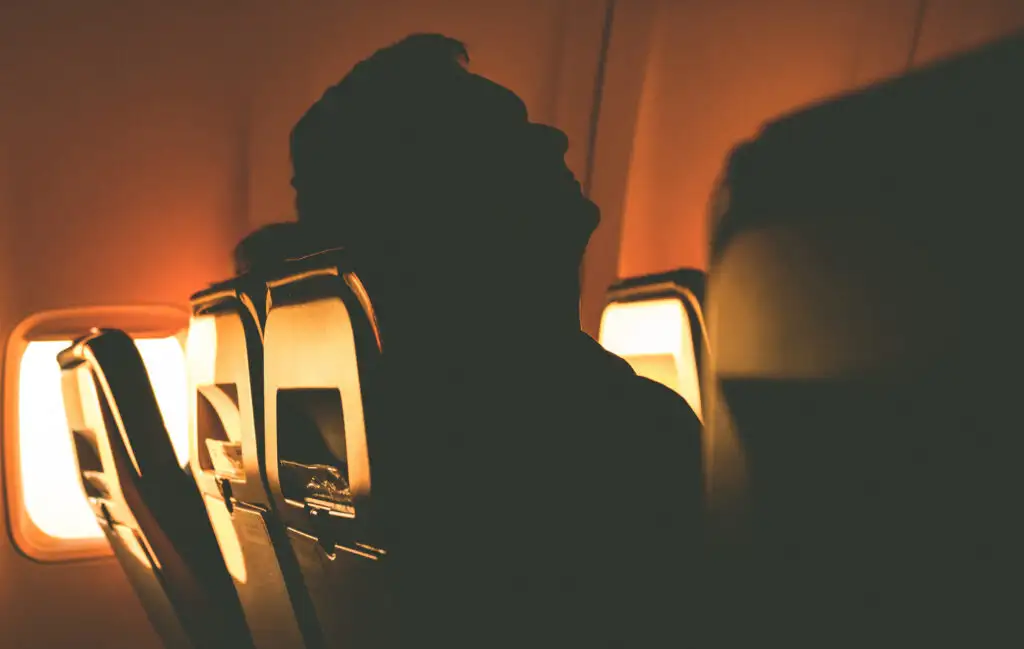 Silhouettes of an sleeping on a plane at sunset