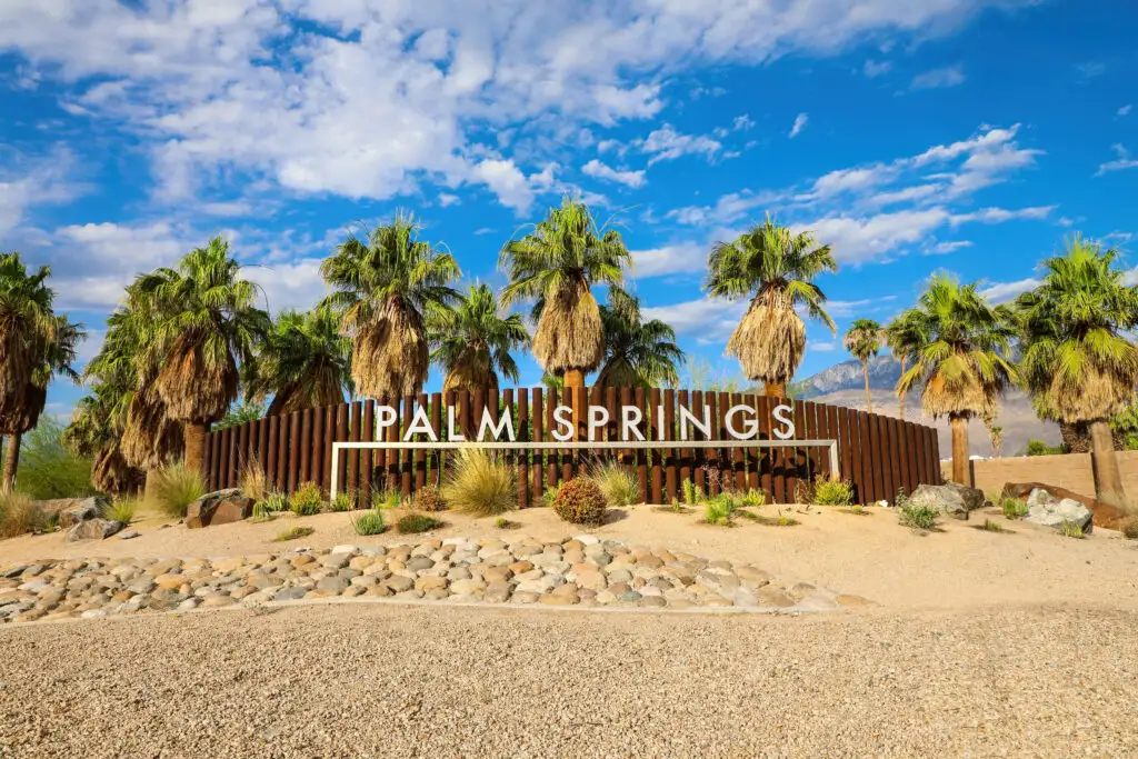 "Palm Springs" sign surrounded by palm trees at the outer edges of Palm Springs, California, United States