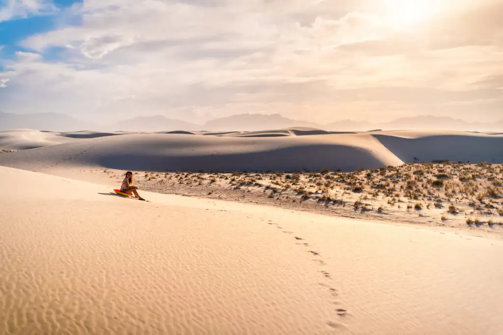 Person sledding down a dune at White Sands National Park in New Mexico, United States