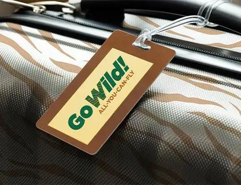 Close up of luggage tag on suitcase reading "Go Wild! All You Can Fly"