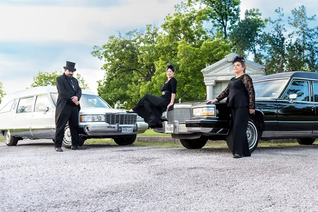 2 unidentified women and 1 unidentified man in a cemetery with Hearses from Haunted ATX