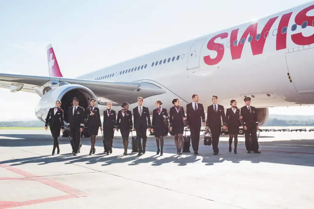 Cabin crew of a SWISS airlines flight walking next to a SWISS aircraft