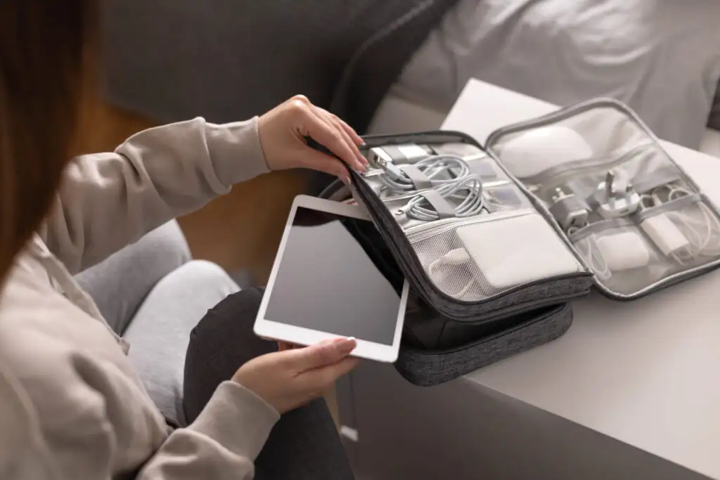 Close up of person packing a tablet device in a small carrying case for electronics and chargers