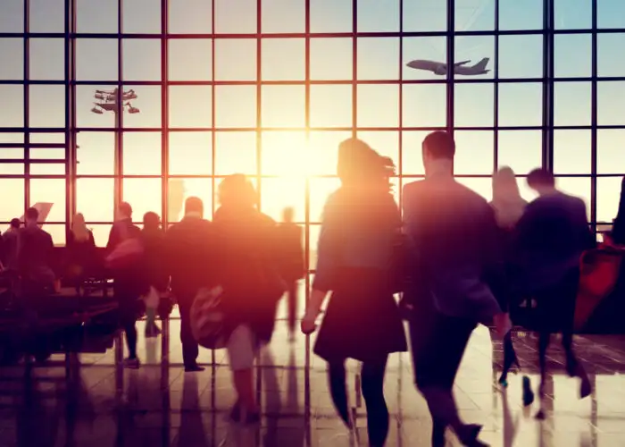 Silhouettes of people in a crowded airport at sunset