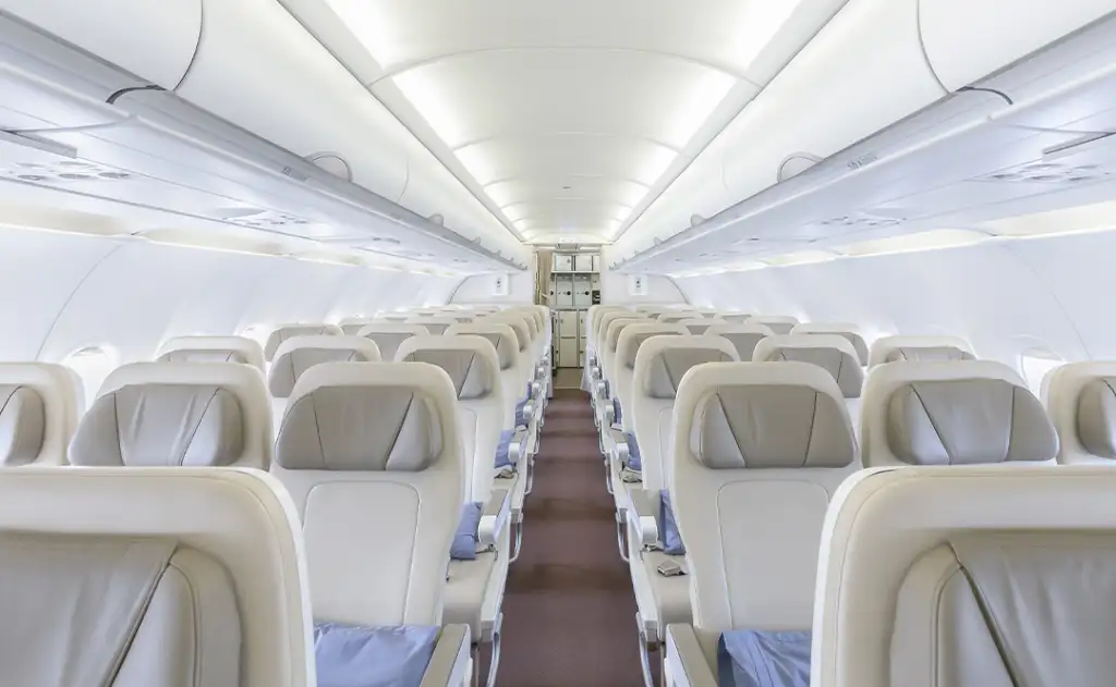 Interior of empty ready to fly airliner cabin with rows of seats.
