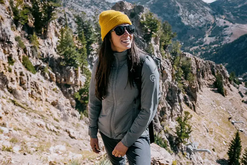Woman hiking on a mountainous trail wearing the Aktivator Hoody from Kuhl