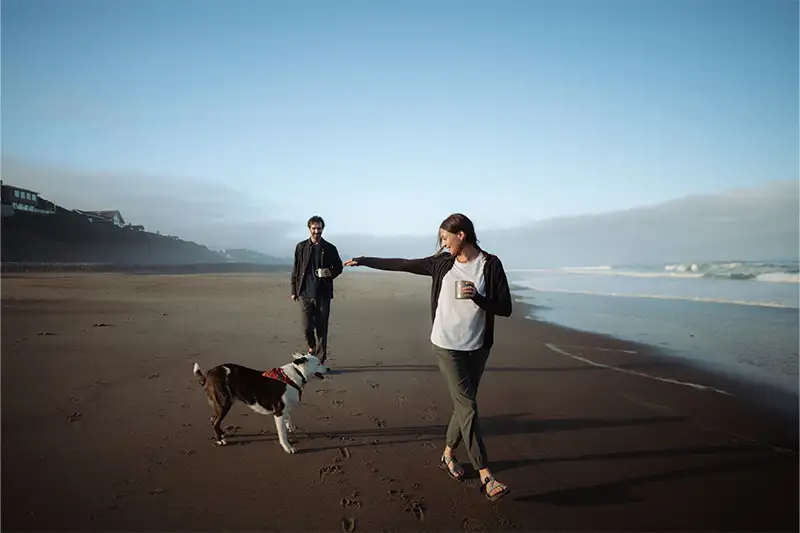 Couple walking along the beach with their dog wearing the Haven Joggers from Kuhl