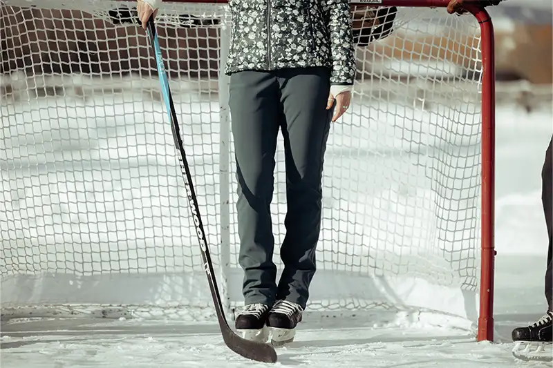 Close up of the legs of a person wearing the Frost Pant from Kuhl while standing in an ice hockey goal
