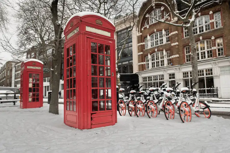 Red phone box in the snow in London, a December vacation spot