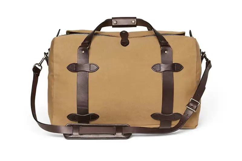 Filson’s Medium Duffle Bag in tan with dark brown leather detailing, a great travel bag for short trips