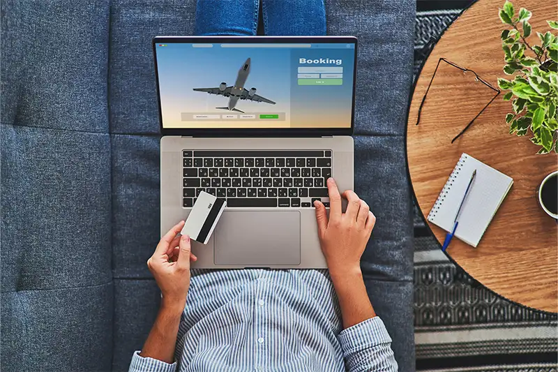 Aerial view of person booking a flight on a laptop