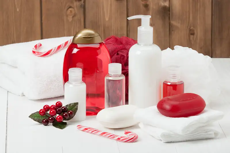 Travel toiletries surrounded by white towels and candy canes