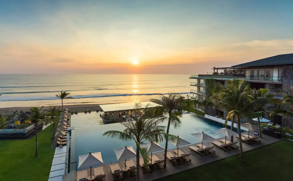Looking over a pool towards the ocean and the setting sun at a Hyatt property