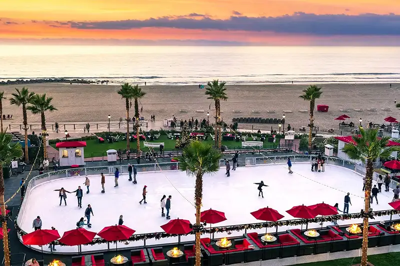 People skating on an open air ice skating rink by the beach at Hotel del Coronado in San Diego, California