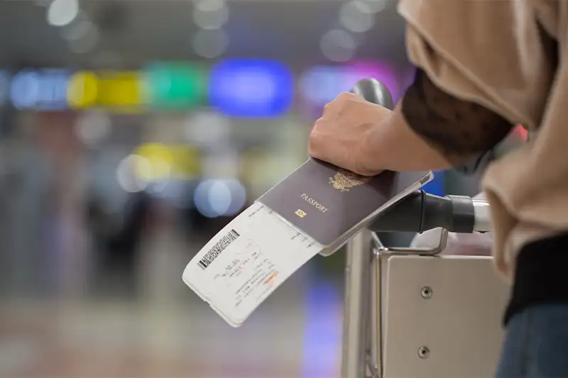 Close up of person holding passport and boarding pass