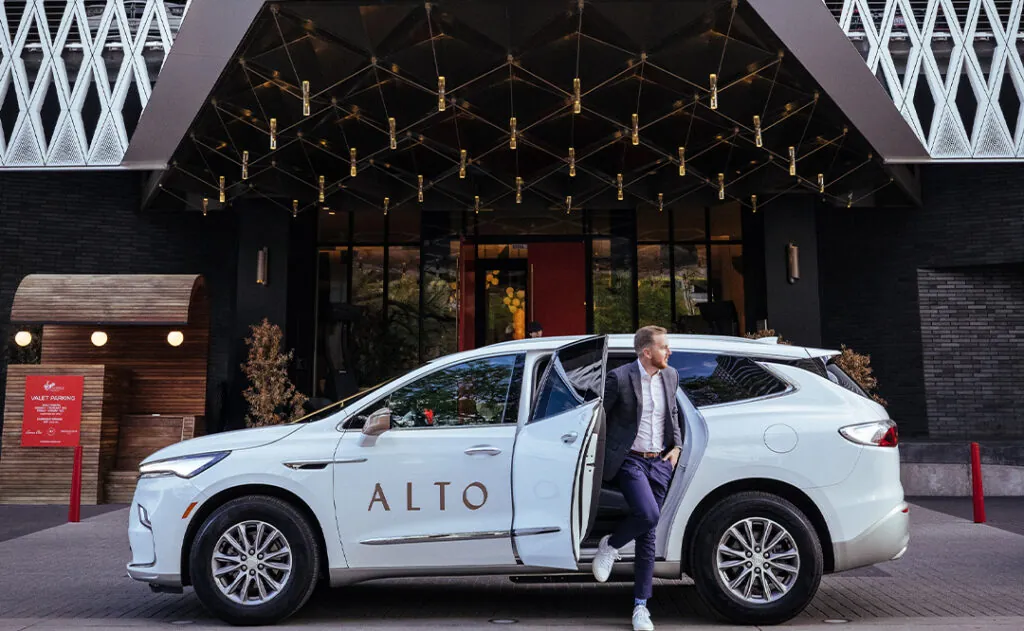 Man exiting Alto ride share vehicle at hotel