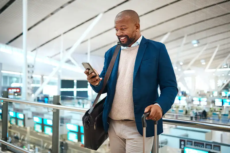 Man checking his phone in an airport