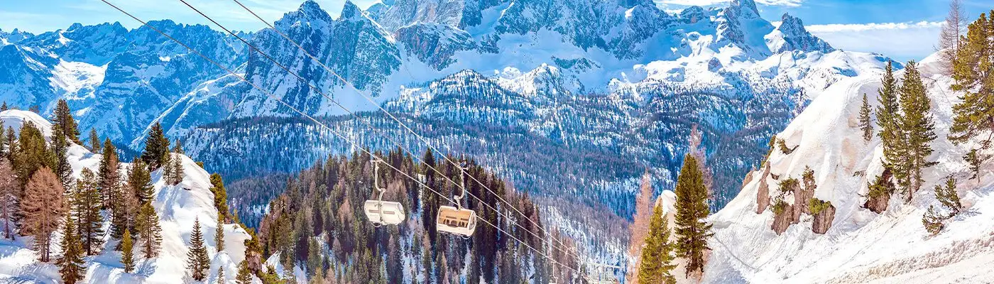 Two chairs on a ski lift in the Dolomites, Italy on a clear day