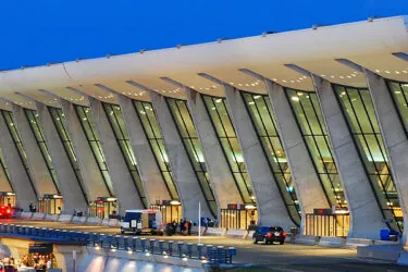 The Main Terminal Building and Air Control Tower of Dulles International Airport is illuminated at dusk