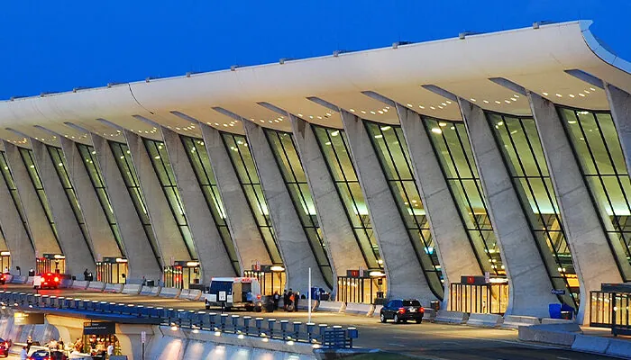 The Main Terminal Building and Air Control Tower of Dulles International Airport is illuminated at dusk