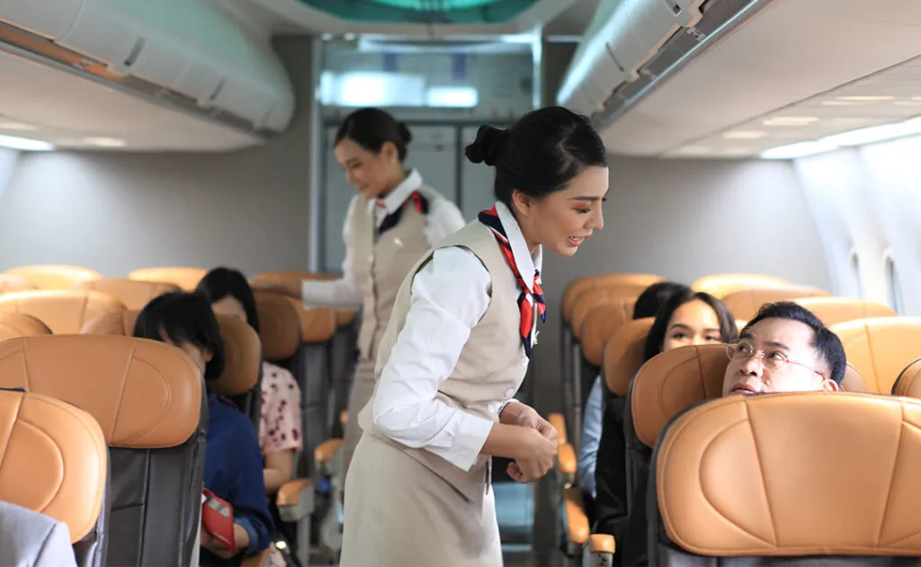 air hostess service on plane , flight attendant checking and closing cabin compartment in airplane