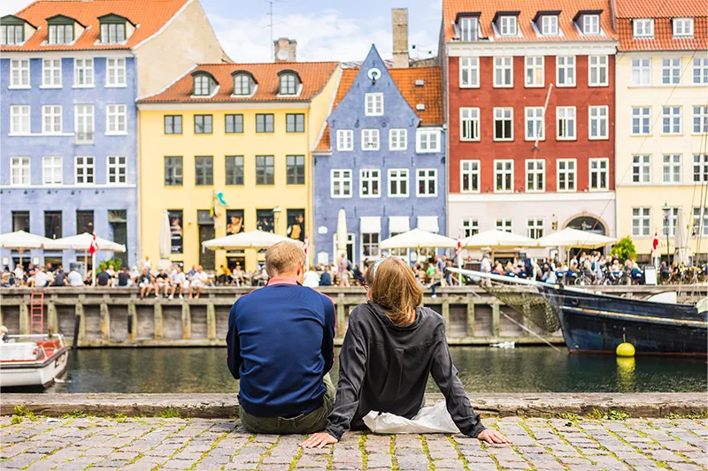 Couple sitting next to canal in Copenhagen, Denmark