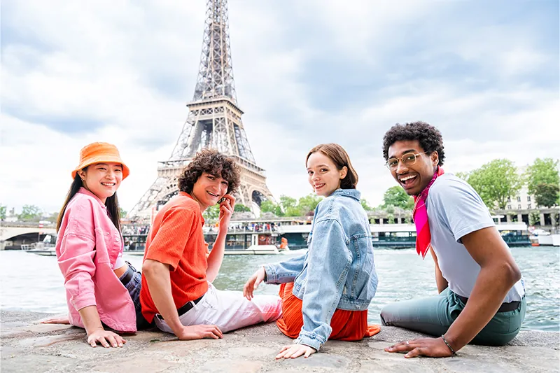 Four friends sitting in front of the Eiffel Tower