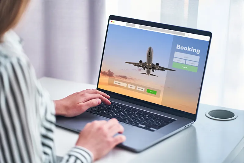 Person booking flight on laptop
