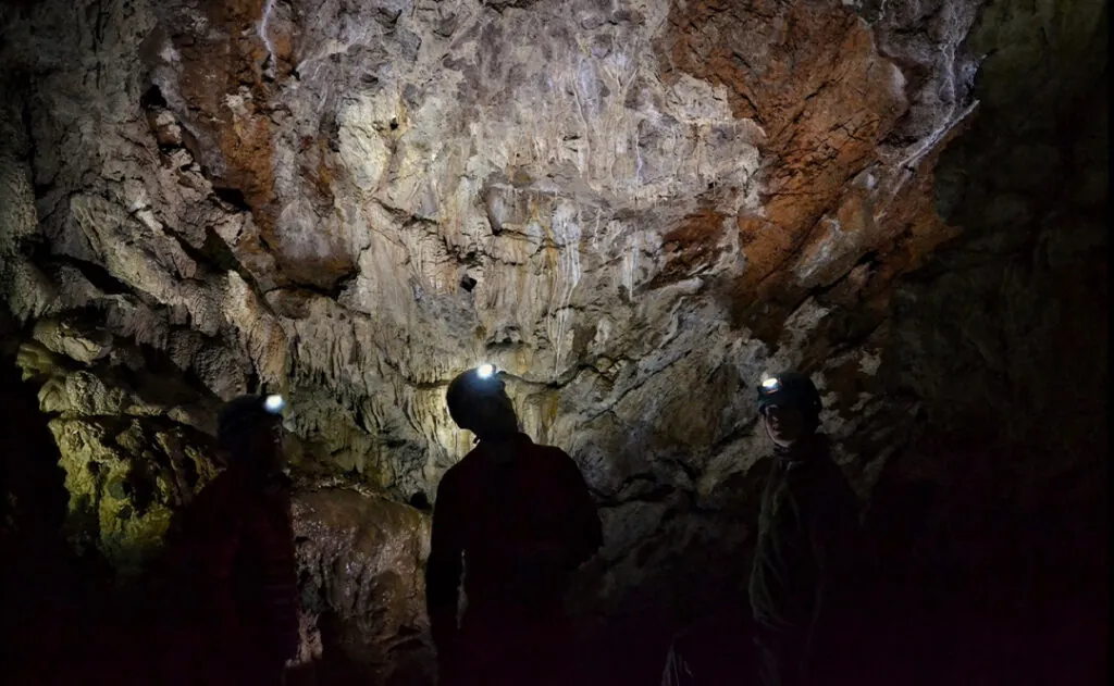 People in Horne Lake Caves in dark with headlamps on