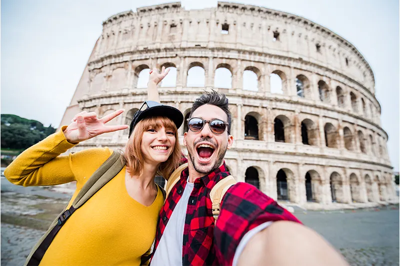 Couple taking a selfie at the Colosseum in Rome